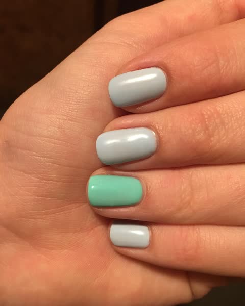 Esmaltação azul-claro com uma unha menta